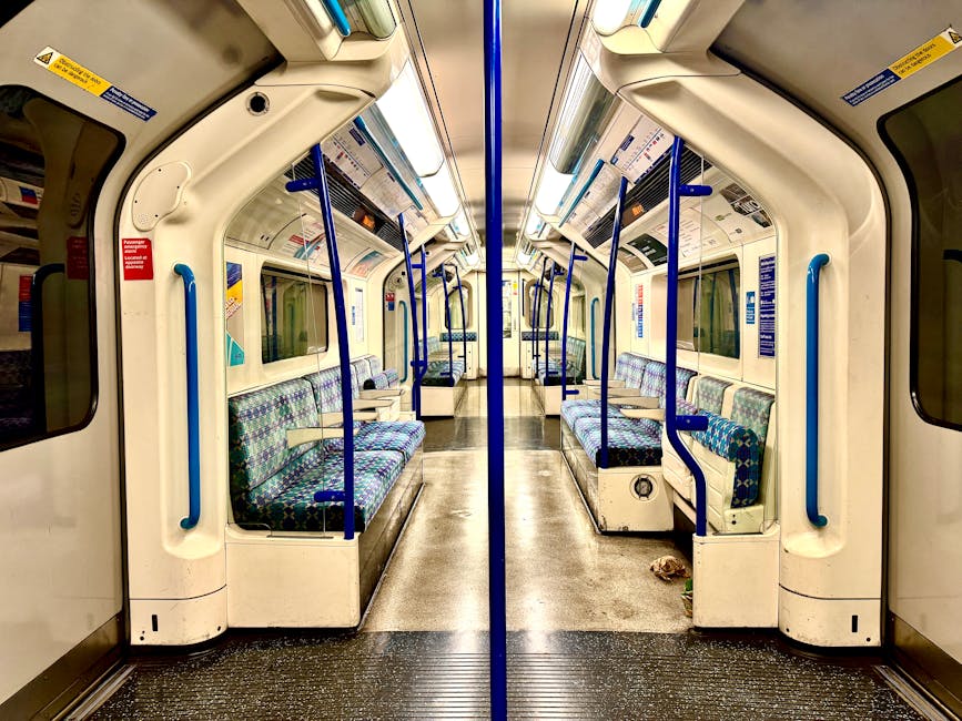 Viewing the entrance of Harlesden Station through a circular window, the exterior features a wall with wood paneling in warm brown tones, complemented by a modern glass door with a metallic frame. The